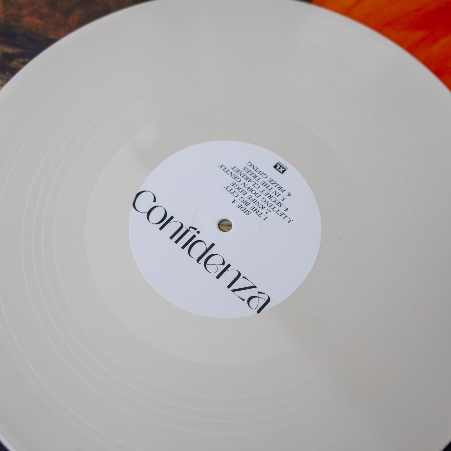 White vinyl record with a label reading ’Confidenza’.